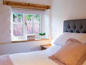 Kingsize bed with white bed linen and pink throw