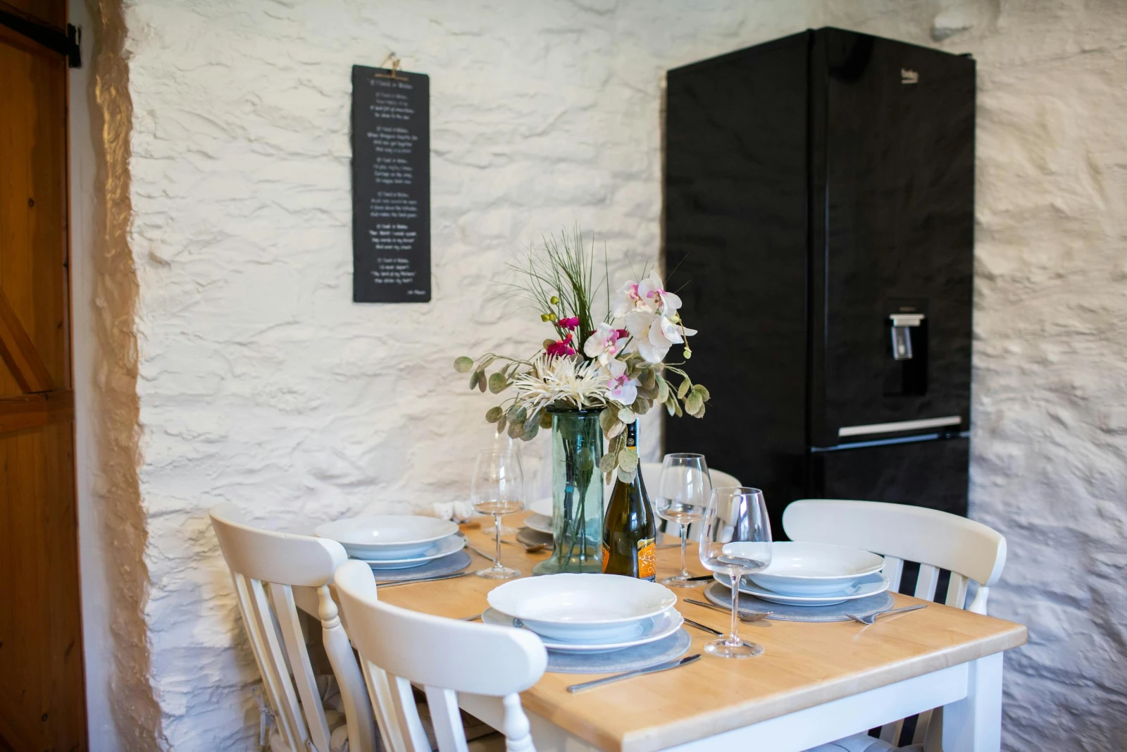 Dining table laid for dinner. Fridge freezer