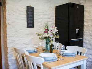 Dining table laid for dinner. Fridge freezer
