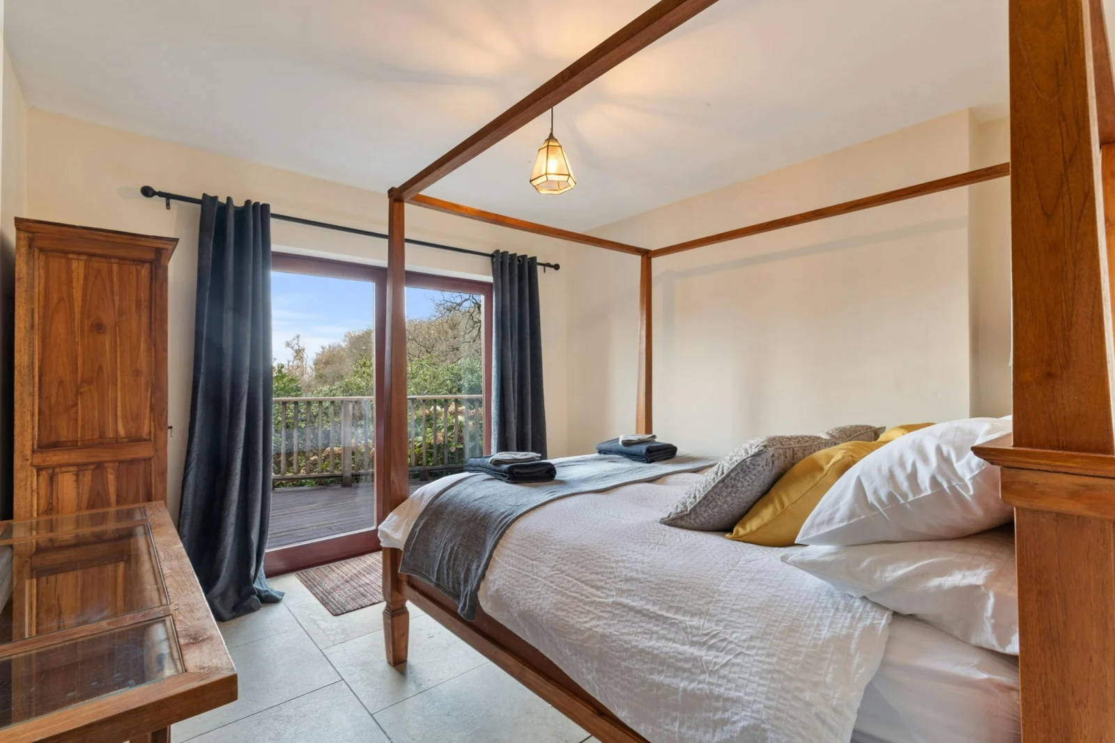 Four poster bed with French doors leading onto the terrace with sea views
