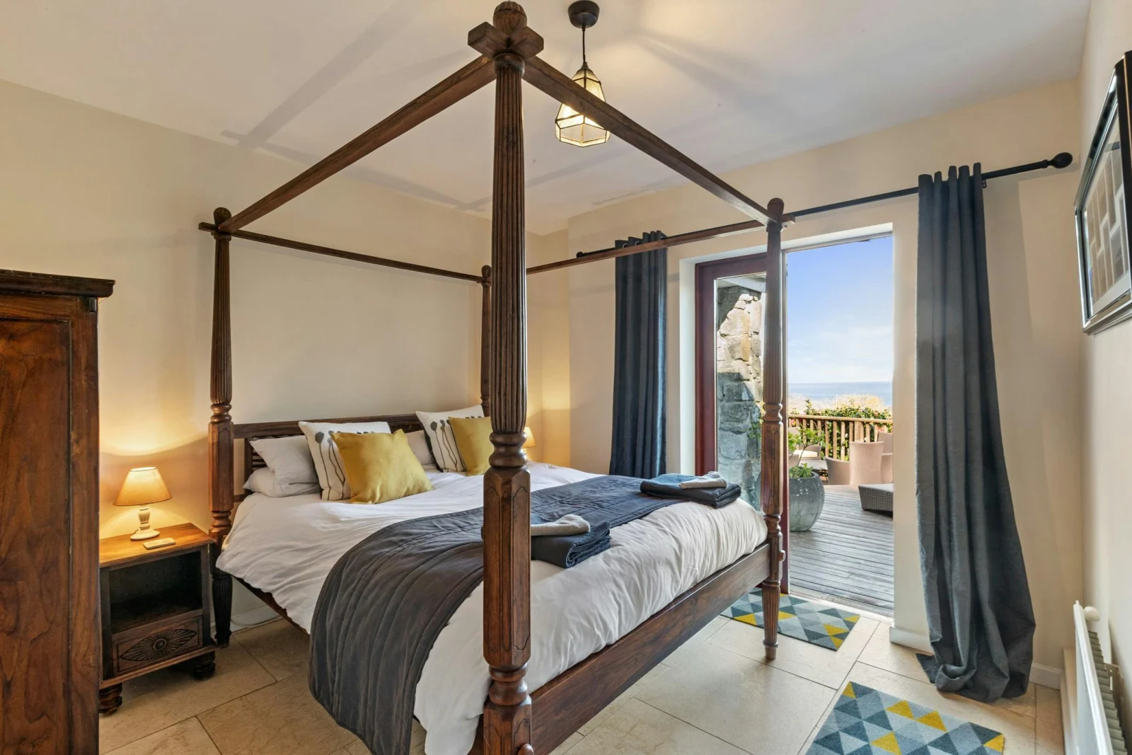 King size four poster bed with bedside tables. French doors leading to the terrace