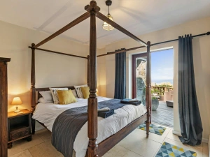 King size four poster bed with bedside tables. French doors leading to the terrace