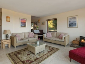 Two sofas and coffee table. Piano and woodburner