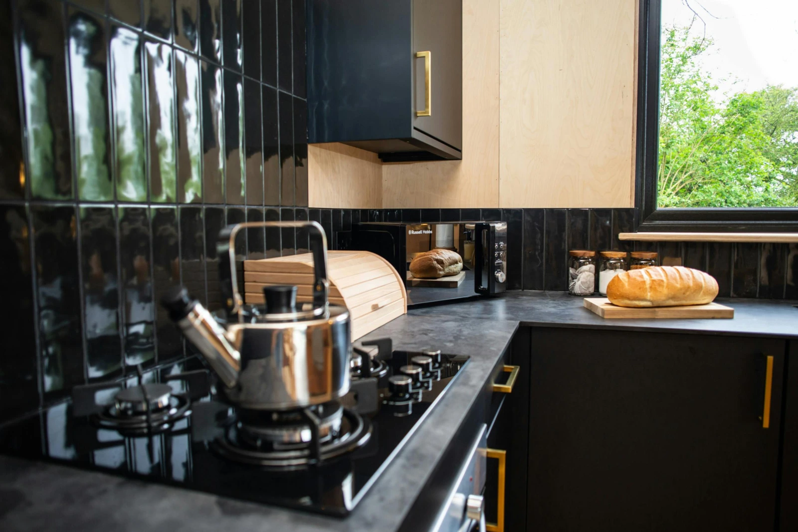 Gas hob with black tiled splashback