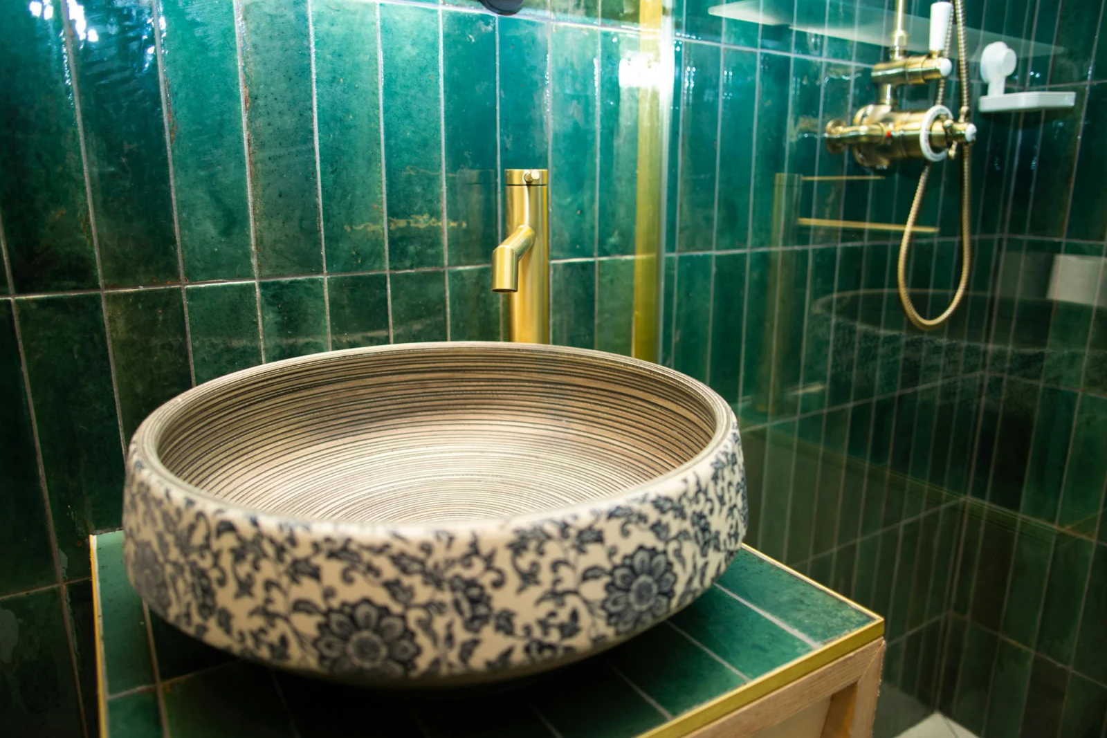 Bathroom with floral designed wash hand basin and brass mixer tap