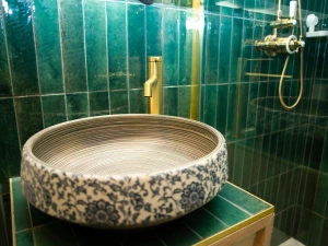Bathroom with floral designed wash hand basin and brass mixer tap
