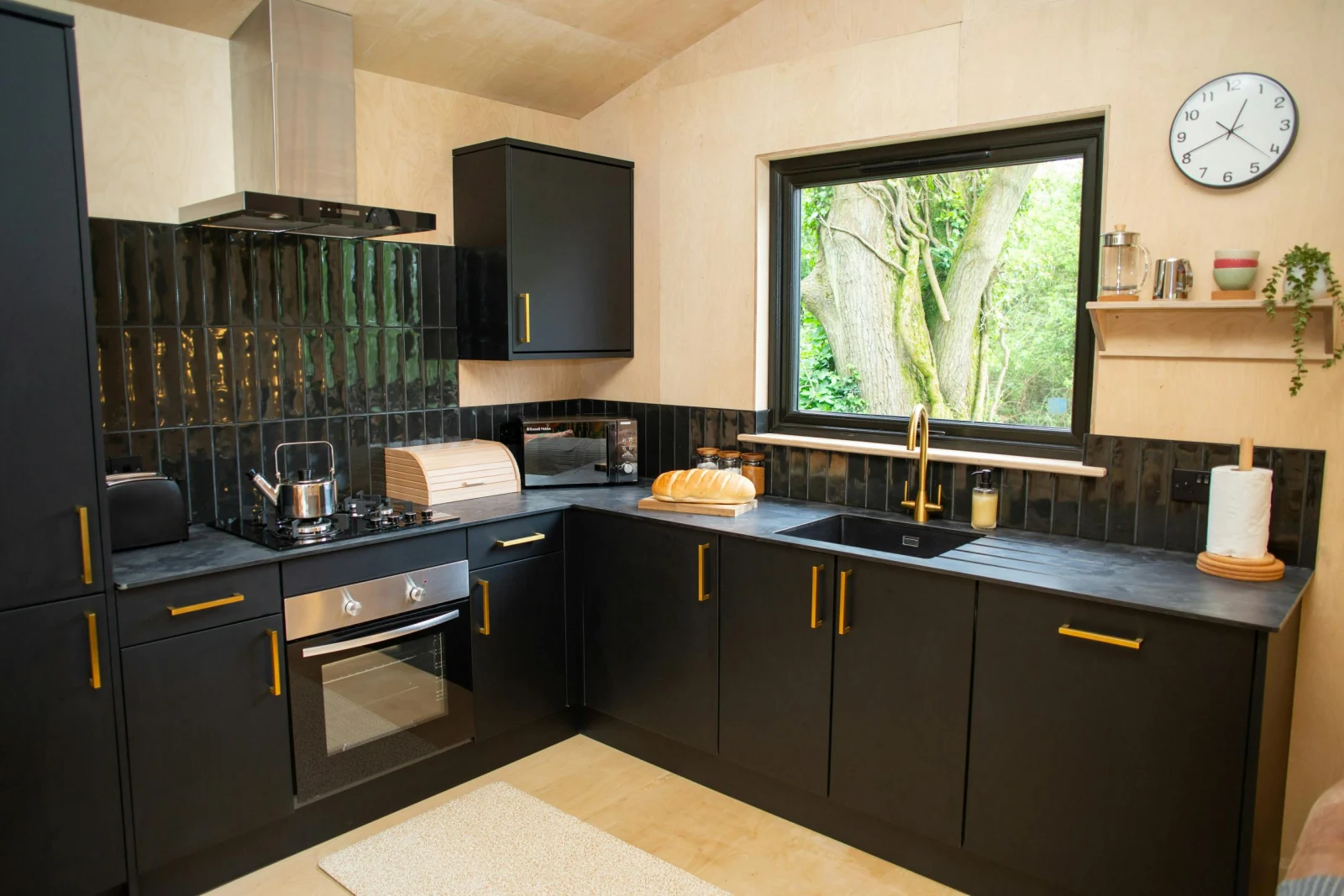 Kitchen with gas hob, electric oven and tiled splash back