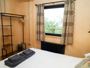 King size bedroom with clothes hanging rail and shelves