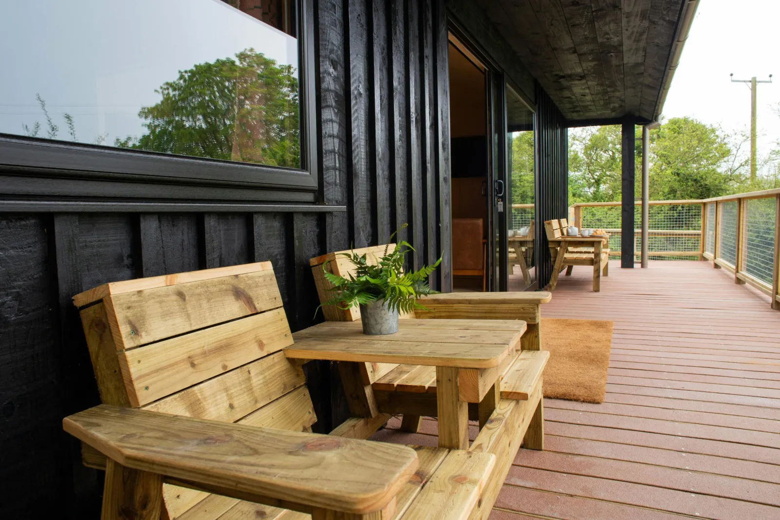 Veranda with wooden seating and table overlooking the lake