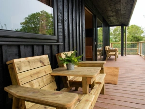 Veranda with wooden seating and table overlooking the lake