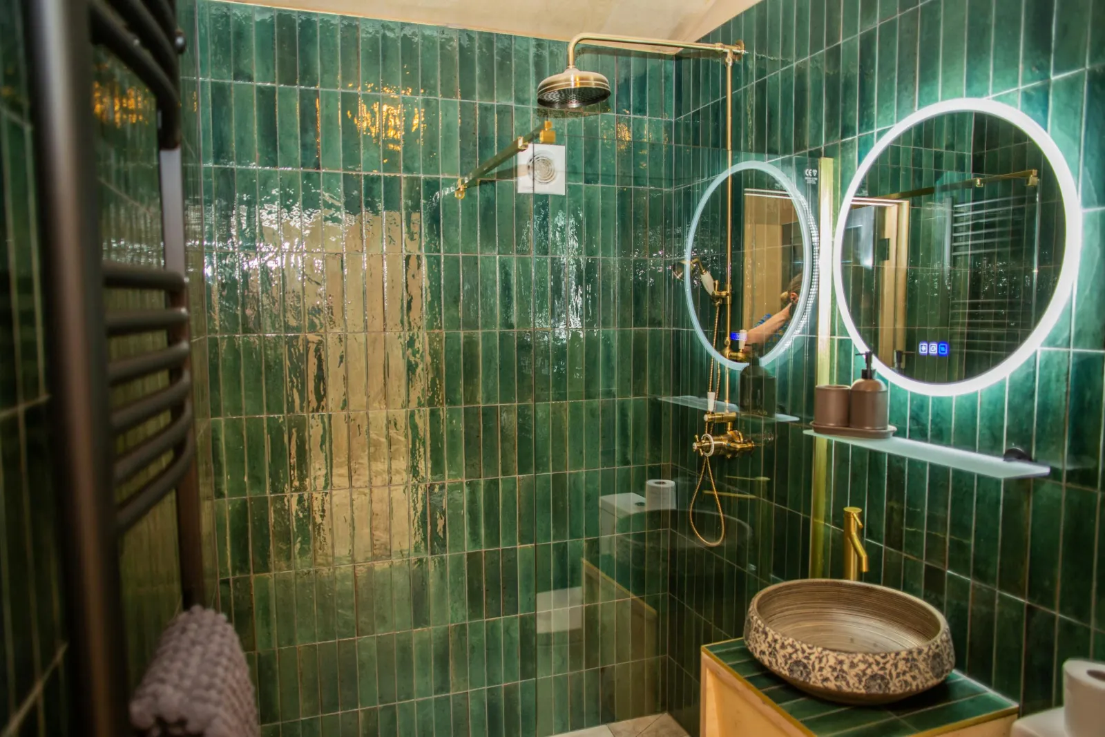 Bathroom with shower cubicle. Fully tiles with brass fitting and a heated towel rail