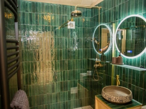 Bathroom with shower cubicle. Fully tiles with brass fitting and a heated towel rail