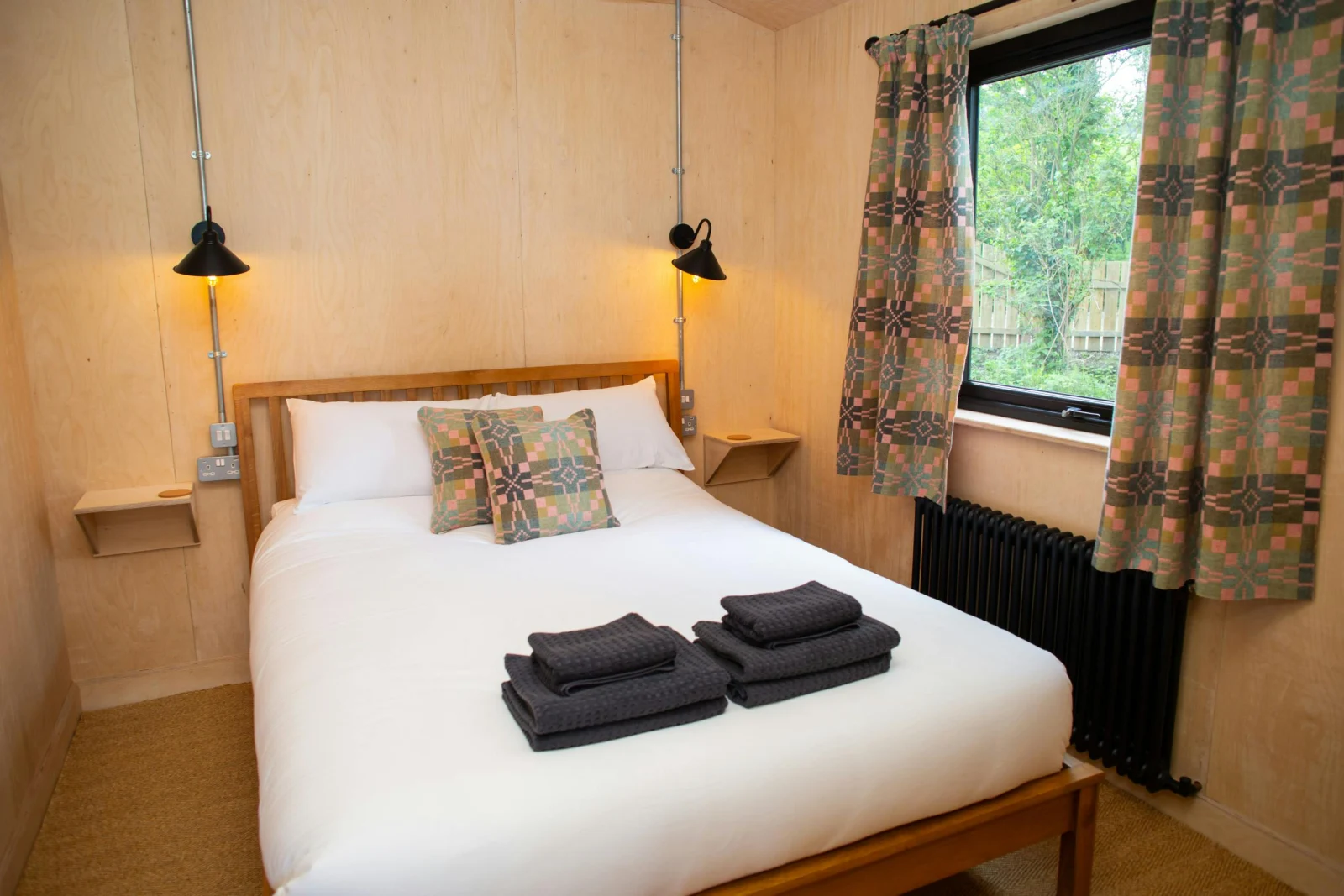King size bed with wall mounted bedside tables and reading lamps