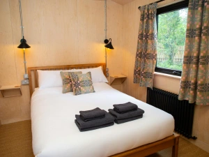 King size bed with wall mounted bedside tables and reading lamps