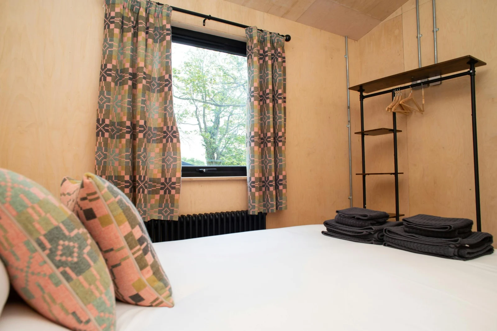 King size bedroom with clothes hanging rail and countryside views from the window