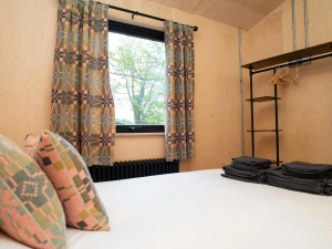 King size bedroom with clothes hanging rail and countryside views from the window