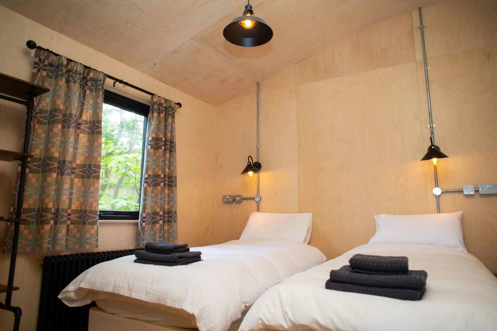 Twin beds with wall mounted reading lights and window with countryside views