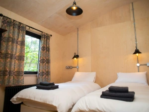 Twin beds with wall mounted reading lights and window with countryside views
