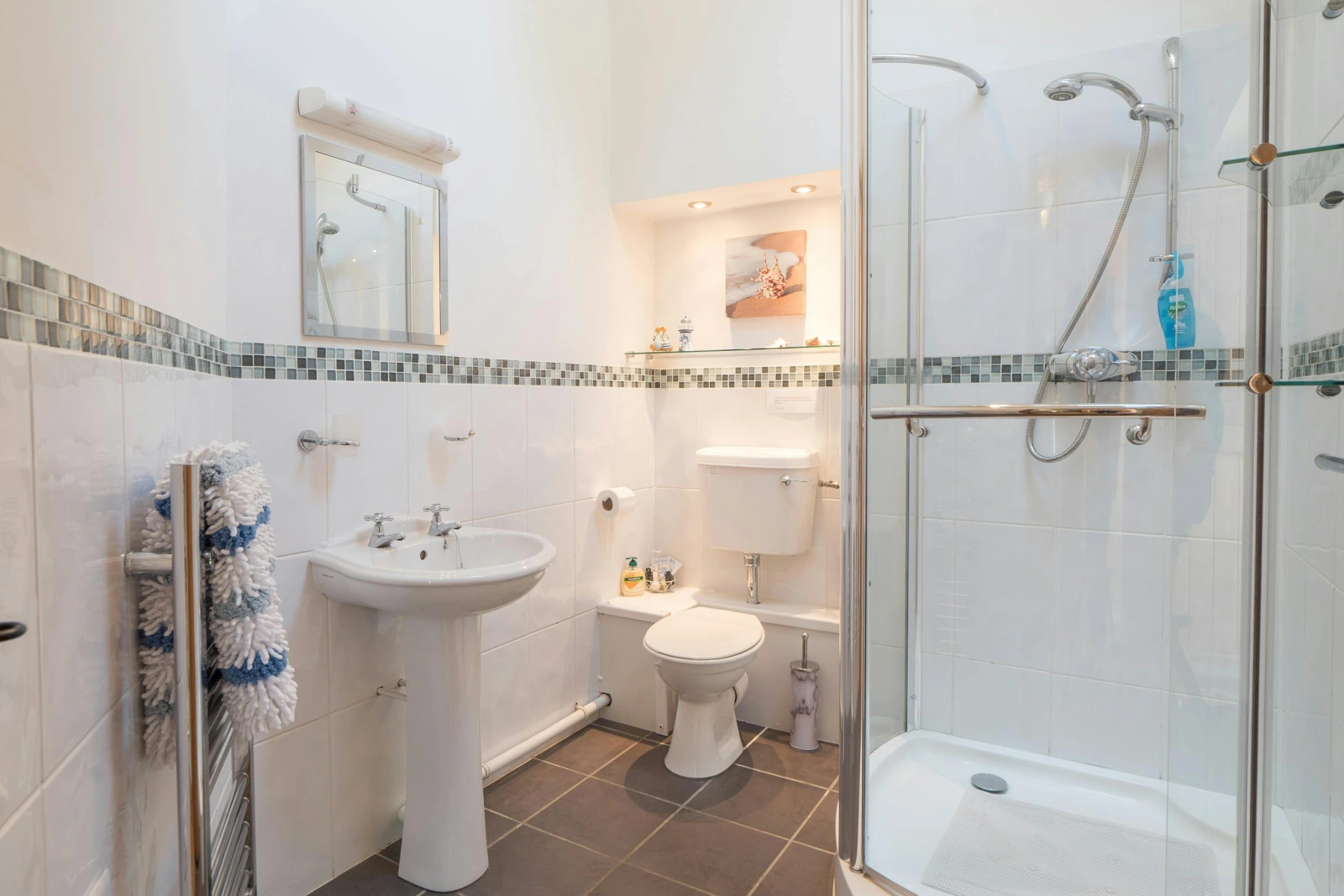 Large shower enclosure, WC, hand basin with mirror above, heated towel rail