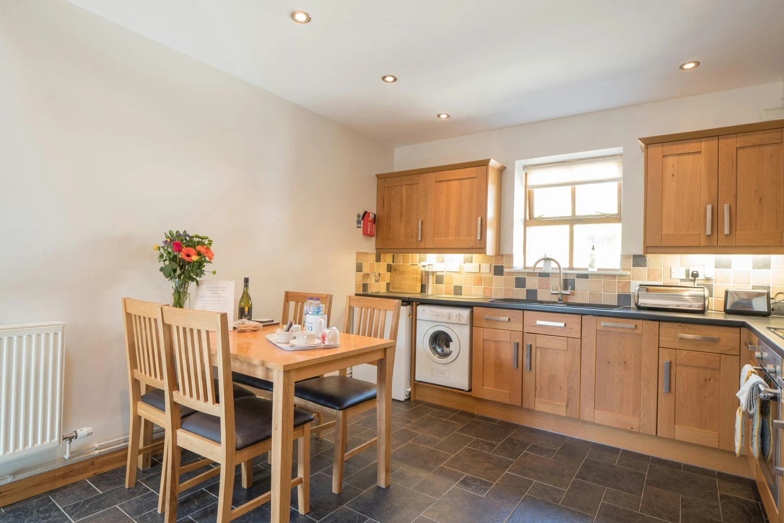 Kitchen/dining room, washing machine, toaster, dishwasher, table with four chairs and window
