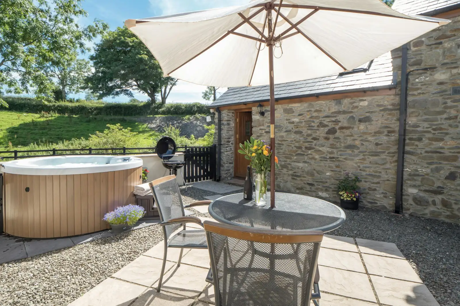 Private patio at Briallen with hot tub, table and chairs