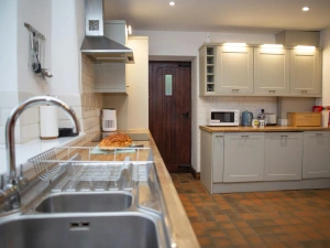 Modern kitchen with sink and drainer in foreground and grey cabinets in background