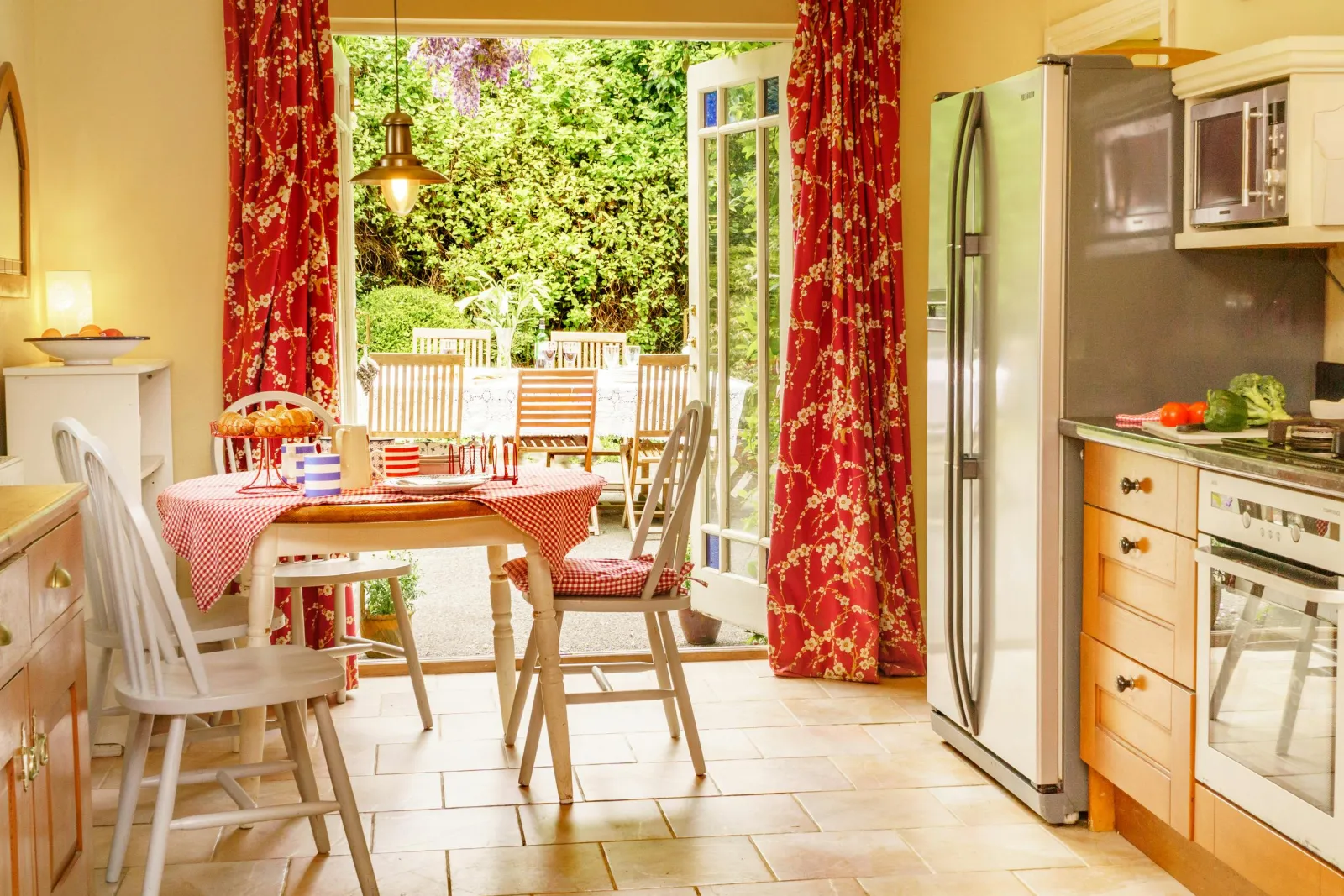Kitchen/diner with patio doors, electric oven, microwave, fridge and small dining table with four chairs