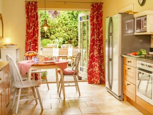 Kitchen/diner with patio doors, electric oven, microwave, fridge and small dining table with four chairs