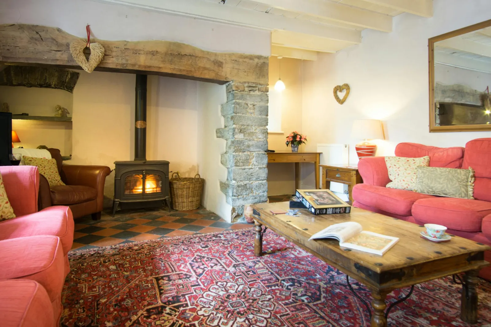 Inglenook with 2 sofas, armchair, coffee table, large wall mirror and log burner