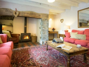 Inglenook with 2 sofas, armchair, coffee table, large wall mirror and log burner