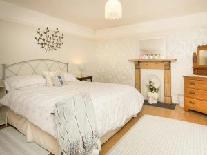 King size bed, bedside table with lamp, chest of drawers and mirror