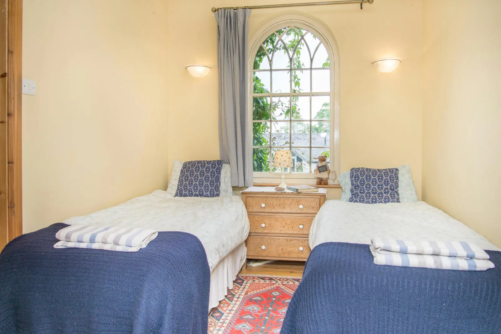 Twin single beds, chest of drawers with lamp