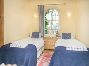 Twin single beds, chest of drawers with lamp