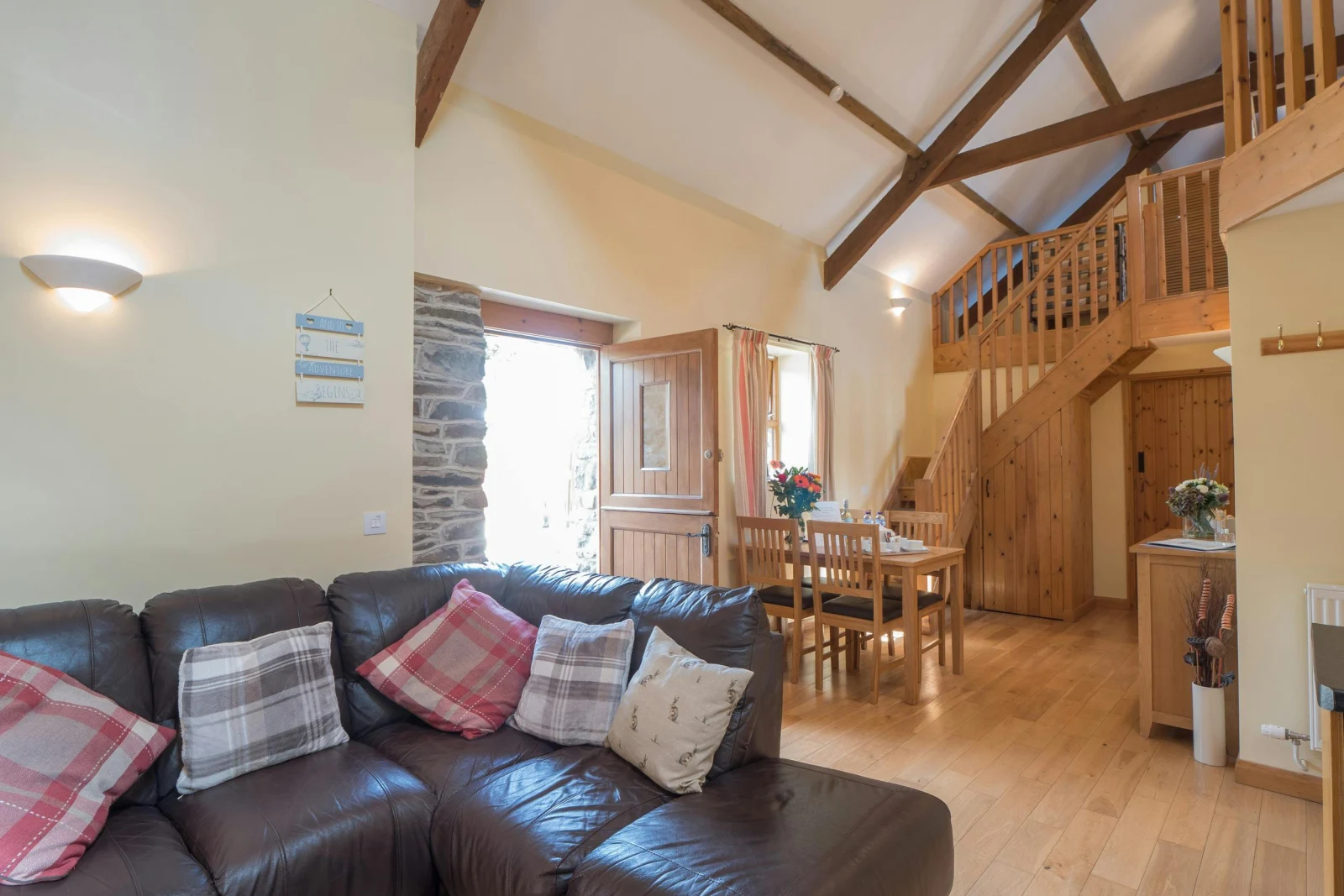 Living/dining area in Eirlys showing sofa, table and chairs, stairs leading to the first floor