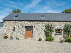 Eirlys, a stone cottage with flower pots in front