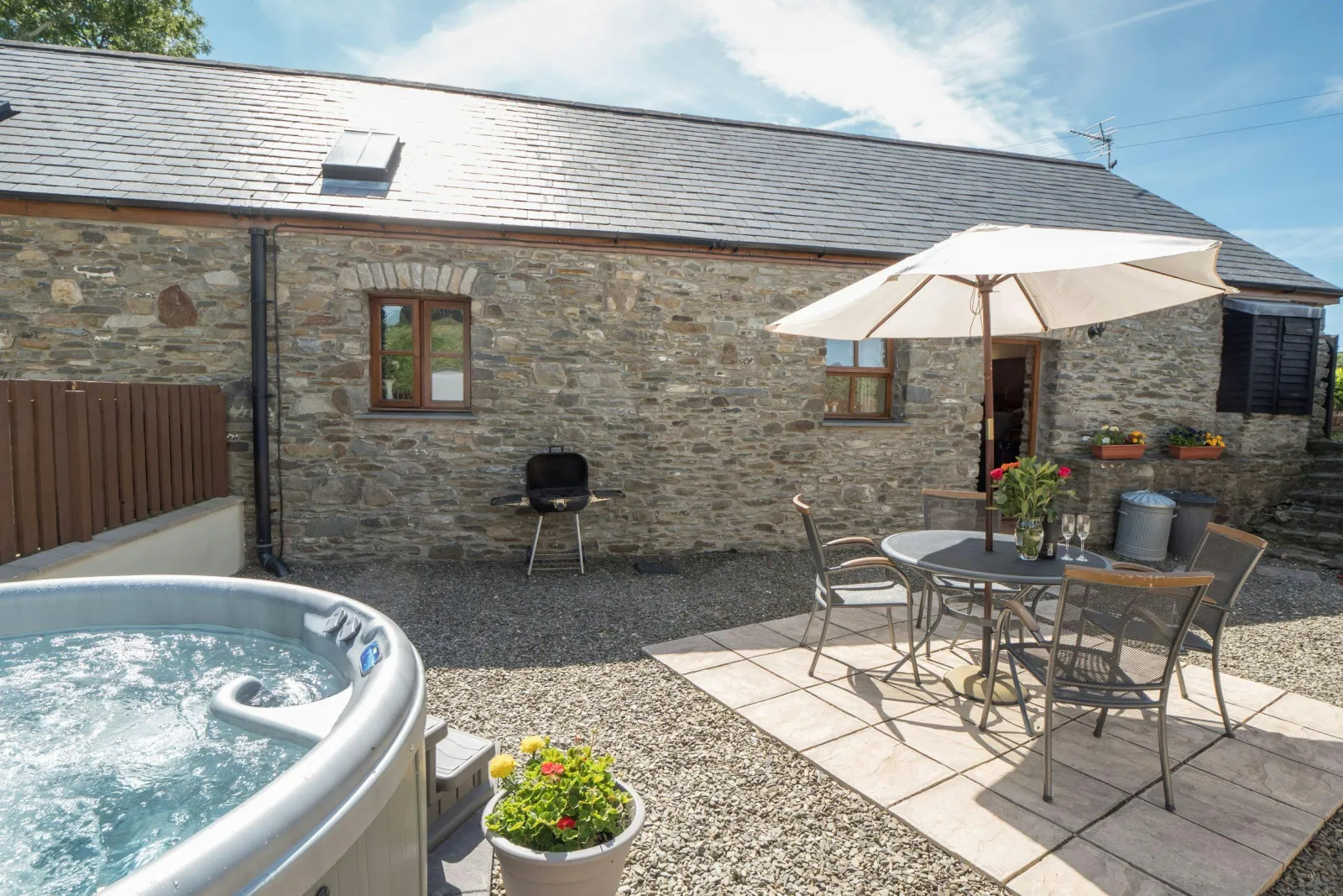 Patio area with table and chairs and hot tub
